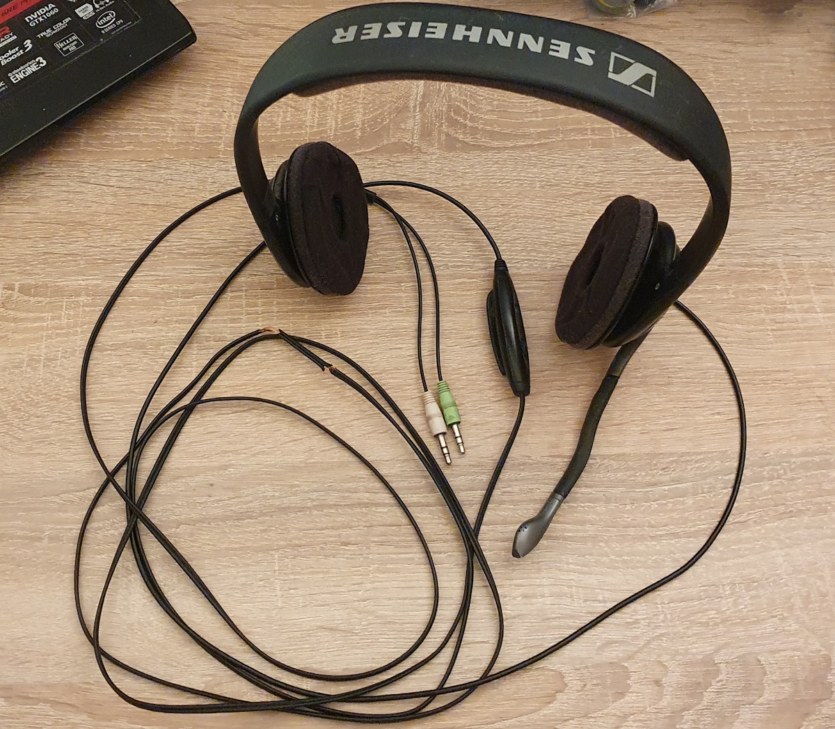 My Sennheiser PC150 on my wooden desk, half-broken cables and all